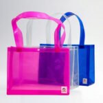 Bolsos en vinilo personalizados en colores rosa, transparente y azul para uso corporativo, promocional y comercial.